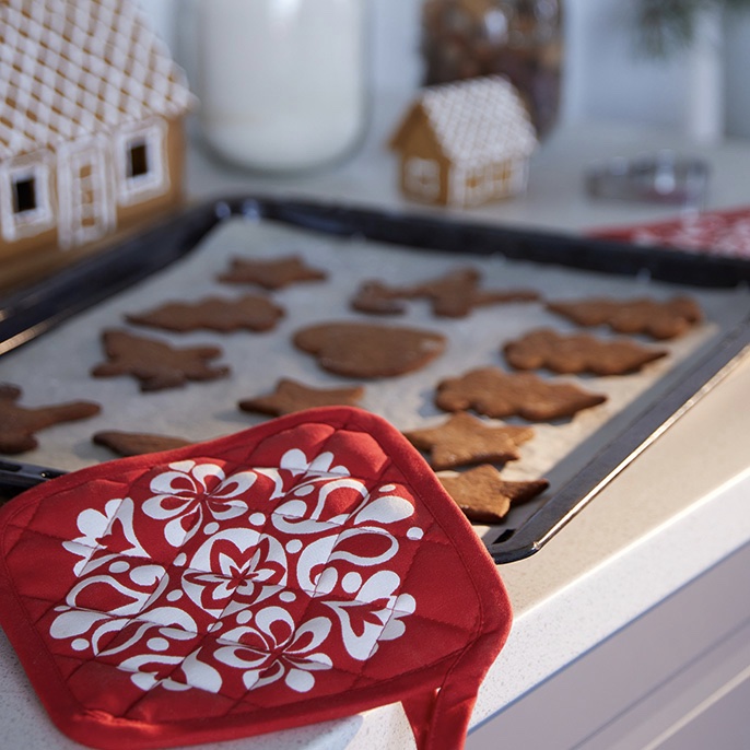 Oven mitt on a tray of cookies.