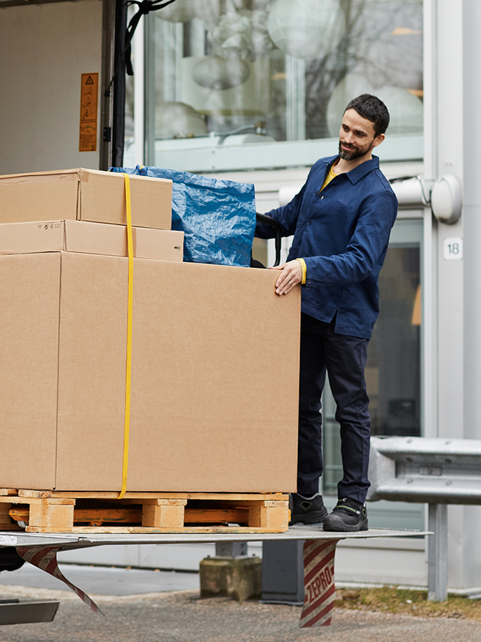 A delivery driver unloads a box to a customer.