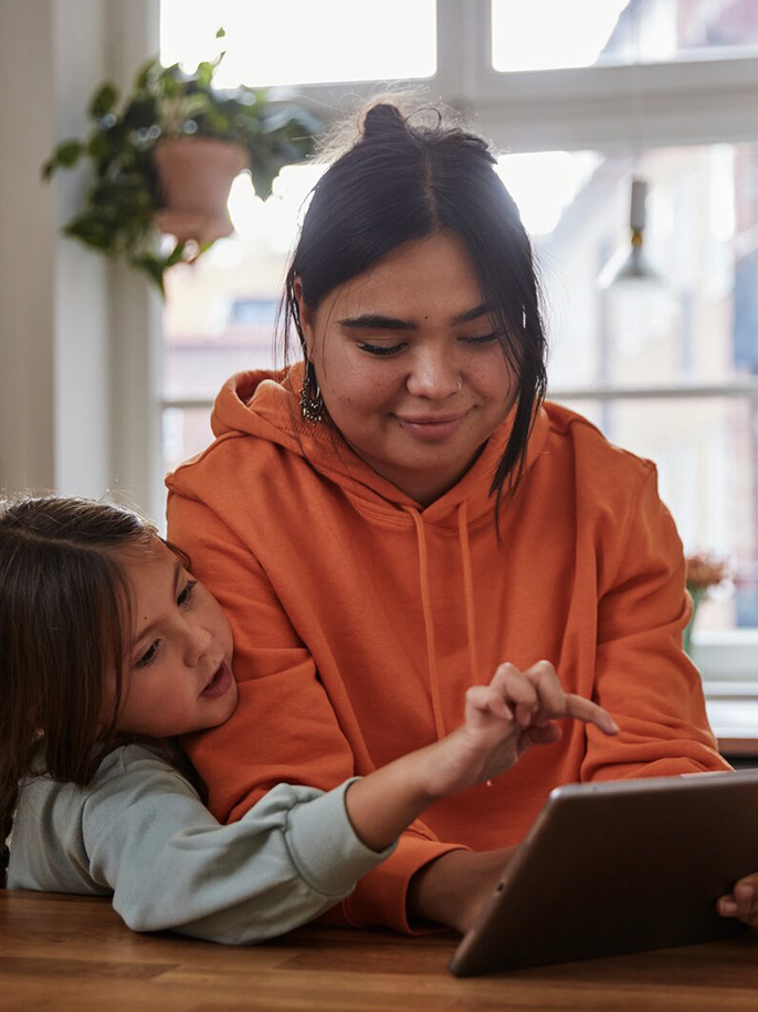 Two people picking out gifts on a tablet together.