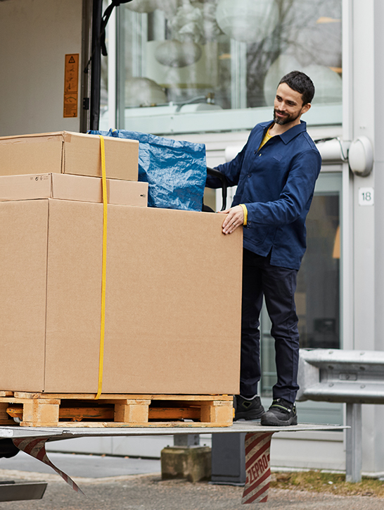 A delivery driver unloads a box to a customer.