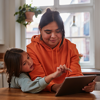 Two people picking out items on a tablet together.